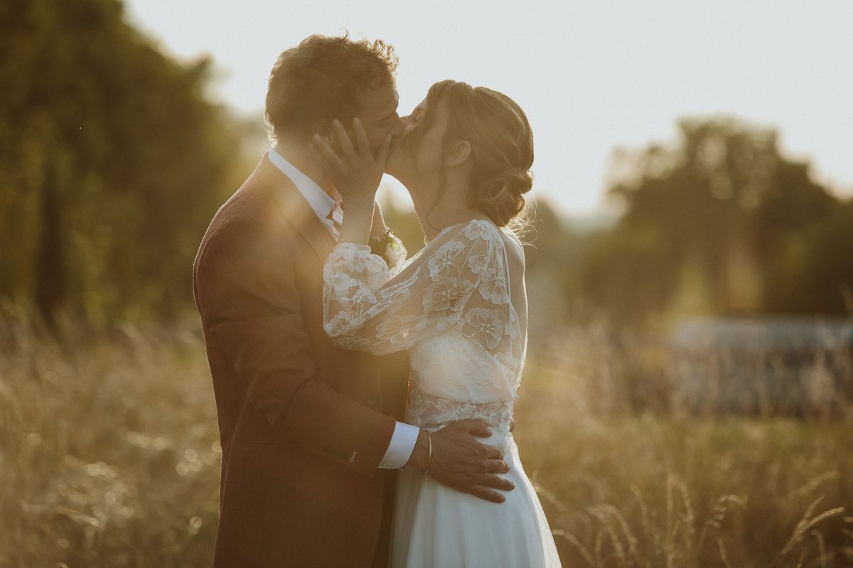 Baiser des mariés au coucher du soleil dans un champ, mariage en Touraine