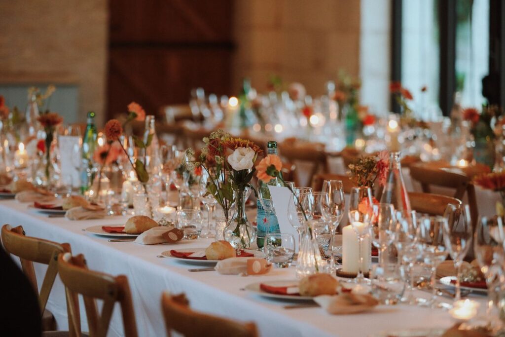 Décoration de table du dîner avec bougies, fleurs et serviettes terracotta, mariage en Touraine