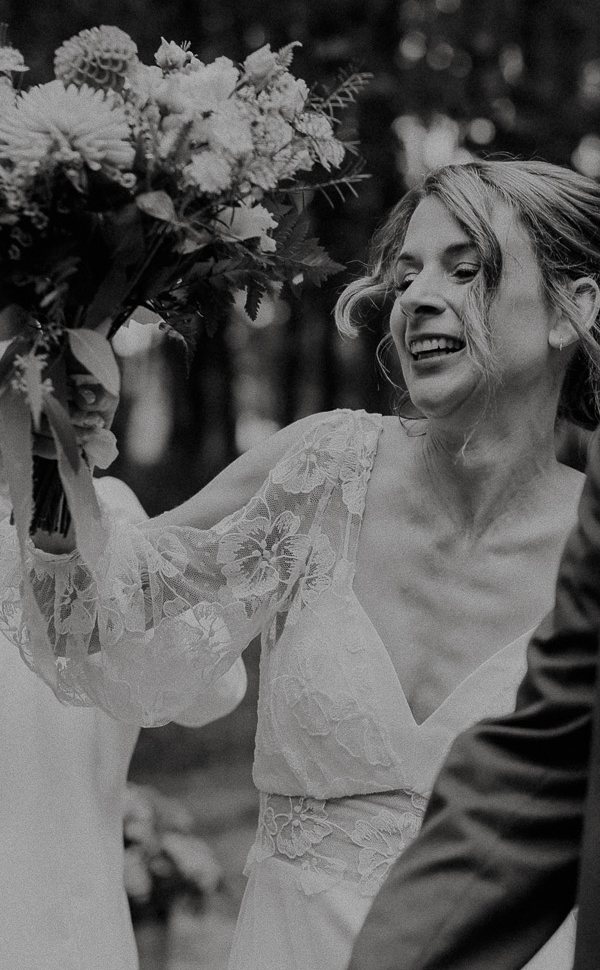 La mariée brandit son bouquet en riant lors de son entrée de cérémonie, mariage en Touraine