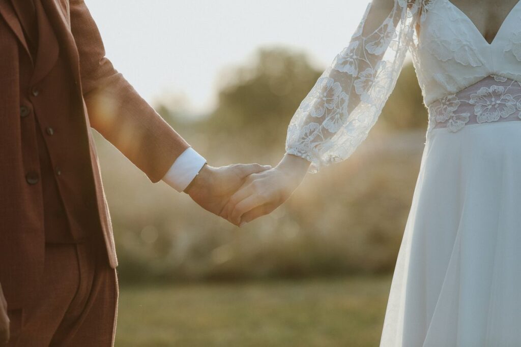 Les mains des mariés enlacées dans la lumière dorée du soir, mariage en Touraine