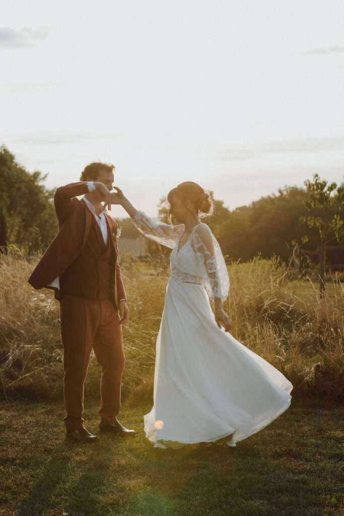 Les mariés dansent dans les herbes hautes à la golden hour, mariage en Touraine