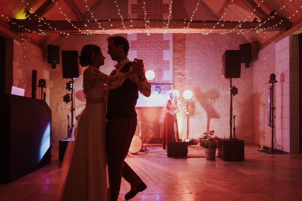Ouverture de bal des mariés sous les guirlandes lumineuses, avec le Just Married Band en fond, mariage en Touraine